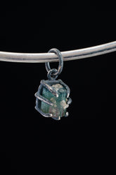 Watermelon Tourmaline Claw Pendant on black background with oxidized sterling silver and natural pink-green crystal.