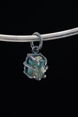 Watermelon Tourmaline Claw Pendant on black background with oxidized sterling silver and natural pink-green crystal.