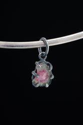 Watermelon Tourmaline Claw Pendant on black background with oxidized sterling silver and natural pink-green crystal.