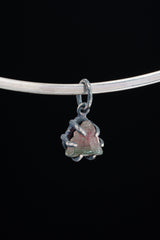 Watermelon Tourmaline pendant on black background shown on silver choker with compact oxidized claw setting.