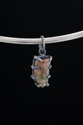 Watermelon Tourmaline Claw Pendant on black background with oxidized sterling silver setting and pink-green gemstone.