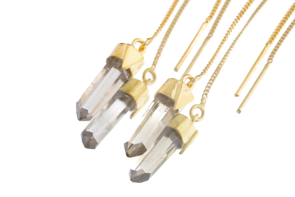 close-up of Himalayan Quartz gold-plated dangle earrings shown with clear crystal points and fine hook fittings.