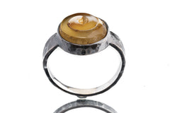 Front view of Fossil Shell oxidized silver ring showing warm organic shell pattern and rugged hammered band texture.