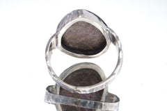 Back view of Sugilite ring showing open-back bezel construction and hammered oxidized sterling silver band.