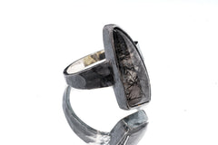 Side view of Rutilated Quartz oxidized silver ring showing long crystal form and rugged hammered band texture.