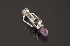 Two Sided Gemstone Spinner Pendant shown on black background with Amethyst Generator, Aquamarine, and sterling silver spinner setting.