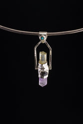 Two Sided Gemstone Spinner Pendant shown on black background with high-polish sterling silver and mixed blue gemstone details.