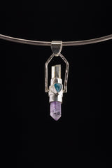 Two Sided Gemstone Spinner Pendant shown angled on black background with Sleeping Beauty Turquoise, Labradorite, and polished silver details.