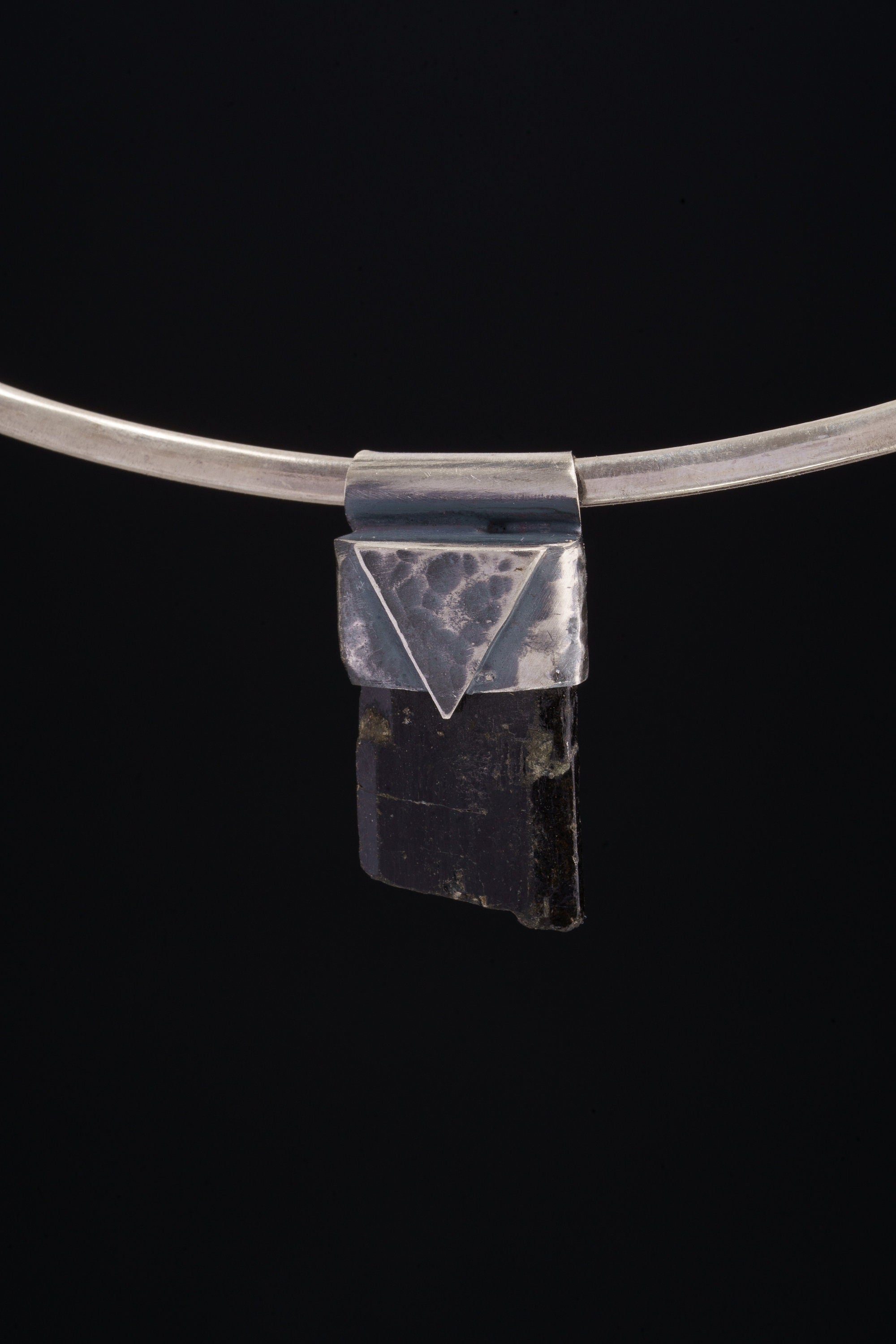 Himalayan Dravite Tourmaline Stack Pendant shown on black background with oxidized 925 silver cap and dark crystal body.