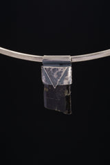 Himalayan Dravite Tourmaline Stack Pendant shown on black background with oxidized 925 silver cap and dark crystal body.