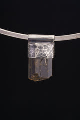 Himalayan Dravite Tourmaline Stack Pendant shown on black background with oxidized 925 silver cap and compact dark crystal body.