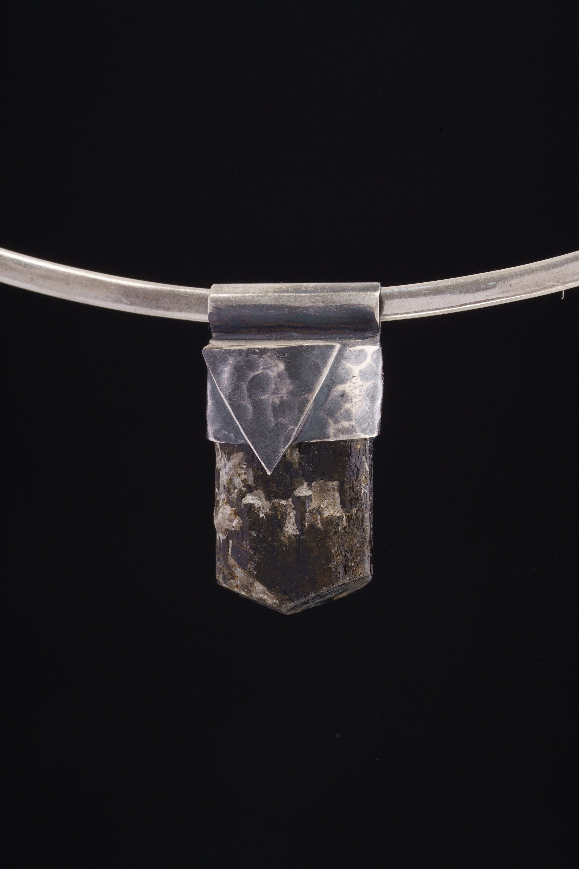 Himalayan Dravite Tourmaline Stack Pendant shown on black background with oxidized sterling silver cap and dark terminated crystal.