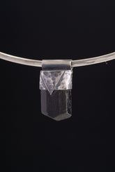 Himalayan Dravite Tourmaline Stack Pendant shown on black background with oxidized sterling silver cap and dark terminated crystal.