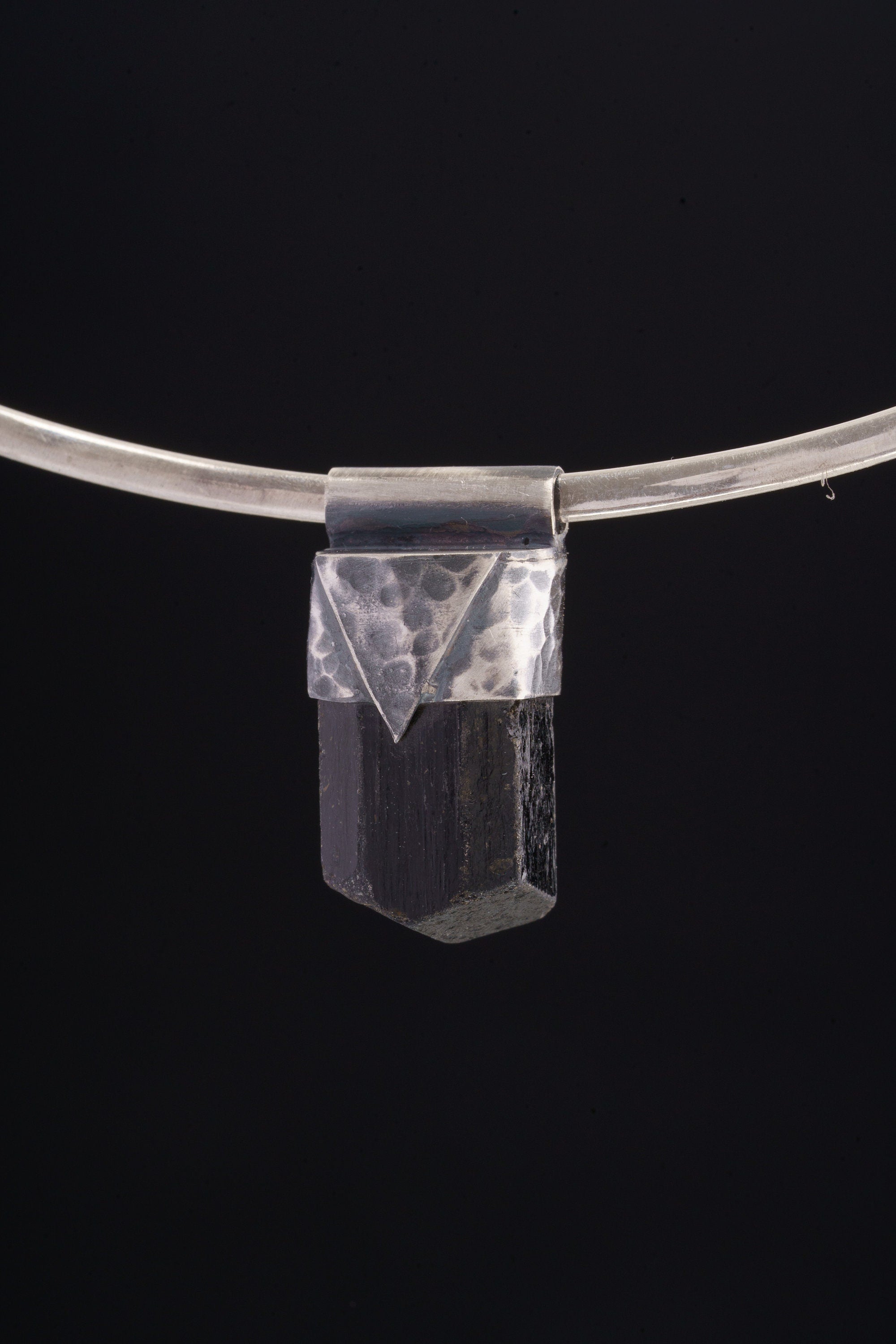 Himalayan Dravite Tourmaline Stack Pendant shown on black background with oxidized sterling silver cap and dark terminated crystal.