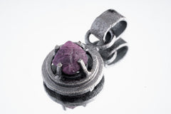 Close-up of Purple Vesuvianite in a gunmetal oxidized sterling silver nest pendant with coarse textured surface.