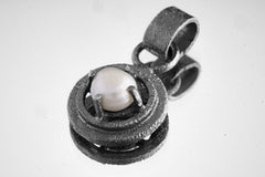 Close-up of a South Sea Pearl pendant in oxidized sterling silver, showing the claw frame, round Pearl glow, and textured bail.