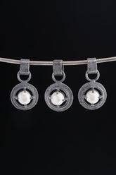 Collection of oxidized 925 sterling silver South Sea Pearl claw pendants with rugged handmade texture on a dark background.