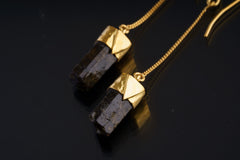 Himalayan Brown Tourmaline earrings shown on a dark background with gold-plated settings and double-terminated crystals.