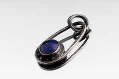 Close-up of deep blue Lapis Lazuli cabochon set in a polished sterling silver Cosmic Ray pendant.