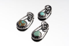 Three Royston Turquoise Cosmic Ray pendants in oxidized 925 sterling silver, showing blue-green stones and celestial ray details.
