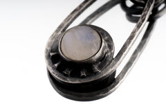 Close-up of natural Moonstone set in a handmade 925 sterling silver pendant with polished silver frame and dual oval bail detail.