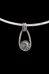 Single Labradorite Cosmic Ray pendant on black background with polished sterling silver frame and dual oval bail.