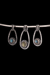 Three handmade Labradorite Cosmic Ray pendants in polished 925 sterling silver, shown on black with dual oval bails and celestial ray details.