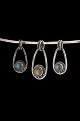 Three handmade Labradorite Cosmic Ray pendants in polished 925 sterling silver, shown on black with dual oval bails and celestial ray details.