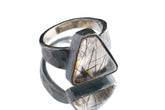 Rutilated Quartz ring in oxidized 925 sterling silver with hammered texture, open-back bezel, and visible rutile strands.