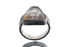 Front view of Rutilated Quartz oxidized silver ring showing needle-like inclusions and strong hammered band profile.