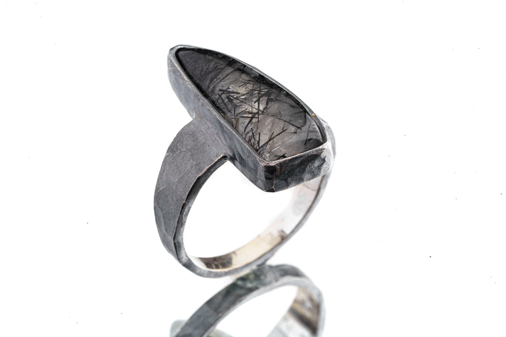Rutilated Quartz ring in oxidized 925 sterling silver with hammered texture, open-back bezel, and visible rutile strands.