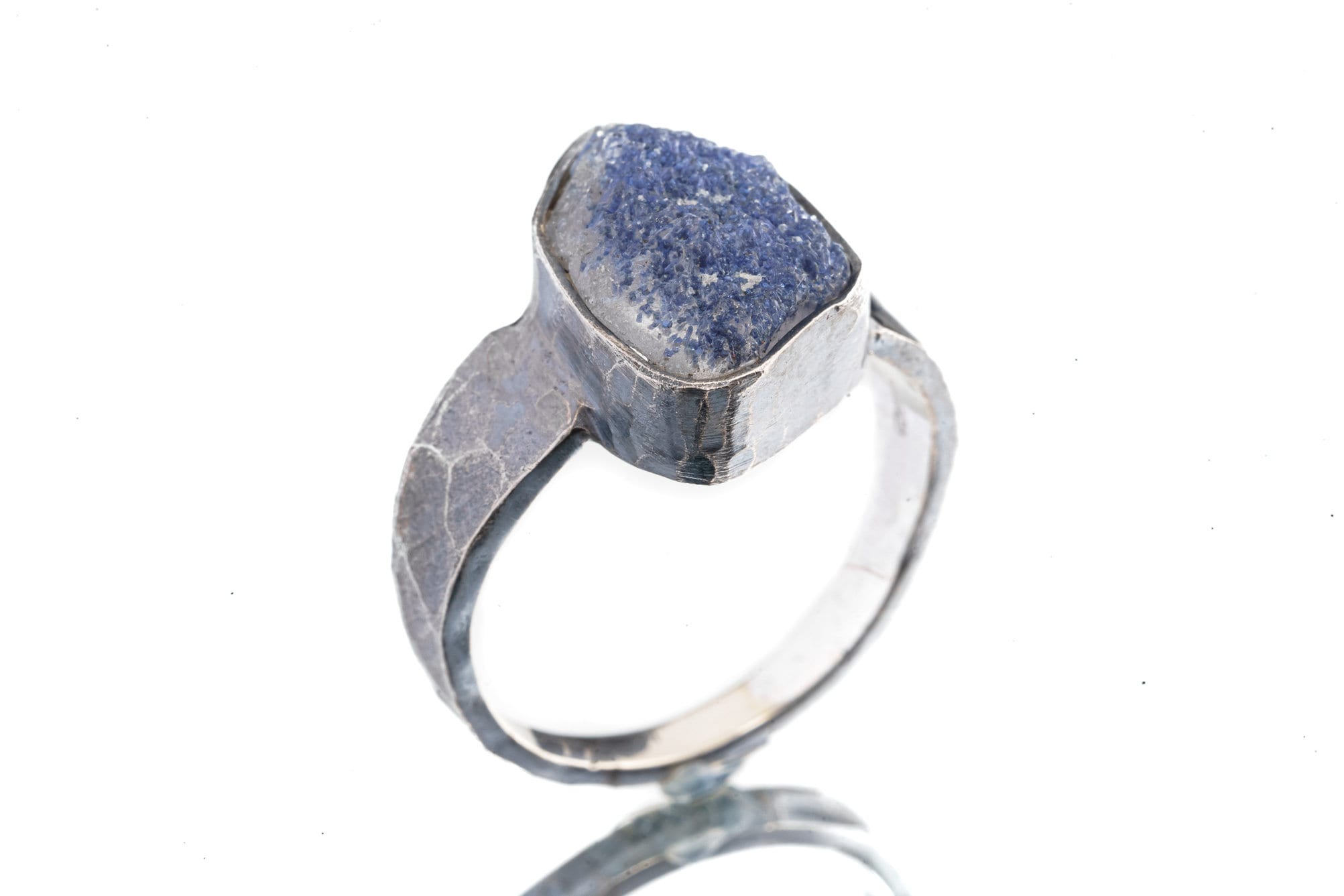 Dumortierite ring in oxidized 925 sterling silver with hammered texture, open-back bezel, and deep blue gemstone.