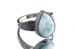 Larimar ring in oxidized 925 sterling silver with hammered texture, open-back bezel, and soft ocean-blue stone.