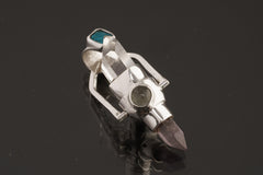 Two Sided Crystal Spinner Pendant shown on black background with blue gemstone detail and high-polish sterling silver setting.