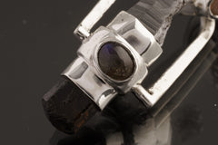 Two Sided Crystal Spinner Pendant shown angled on black background with Aquamarine, Labradorite, Opal, and polished silver details.