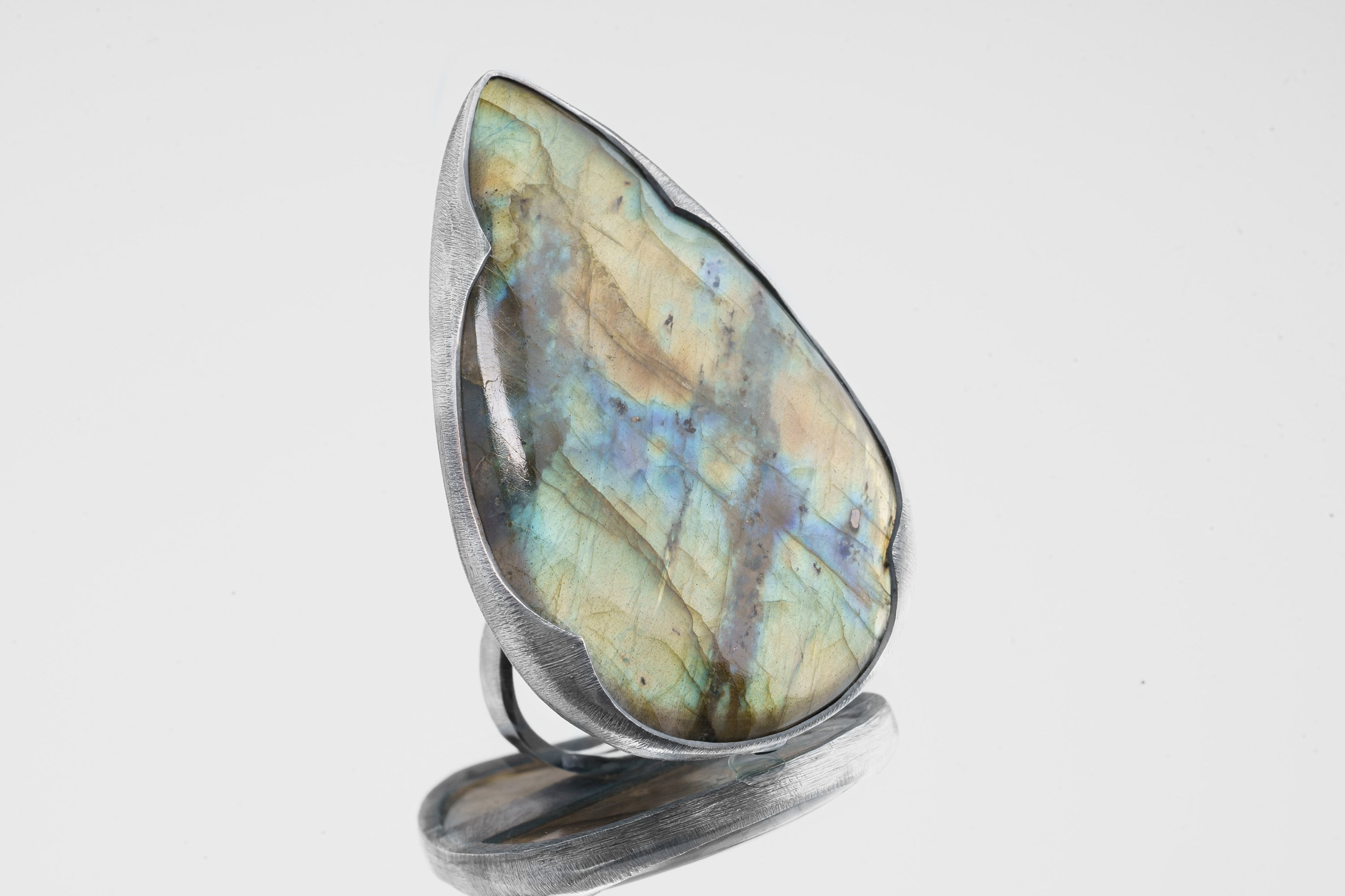 XXL Labradorite adjustable ring in shiny 925 sterling silver with large flashing stone and thick waved bezel setting.
