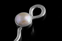 Close-up of South Sea Pearl spoon pendant showing luminous Pearl, loop bail, and polished sterling silver casting.