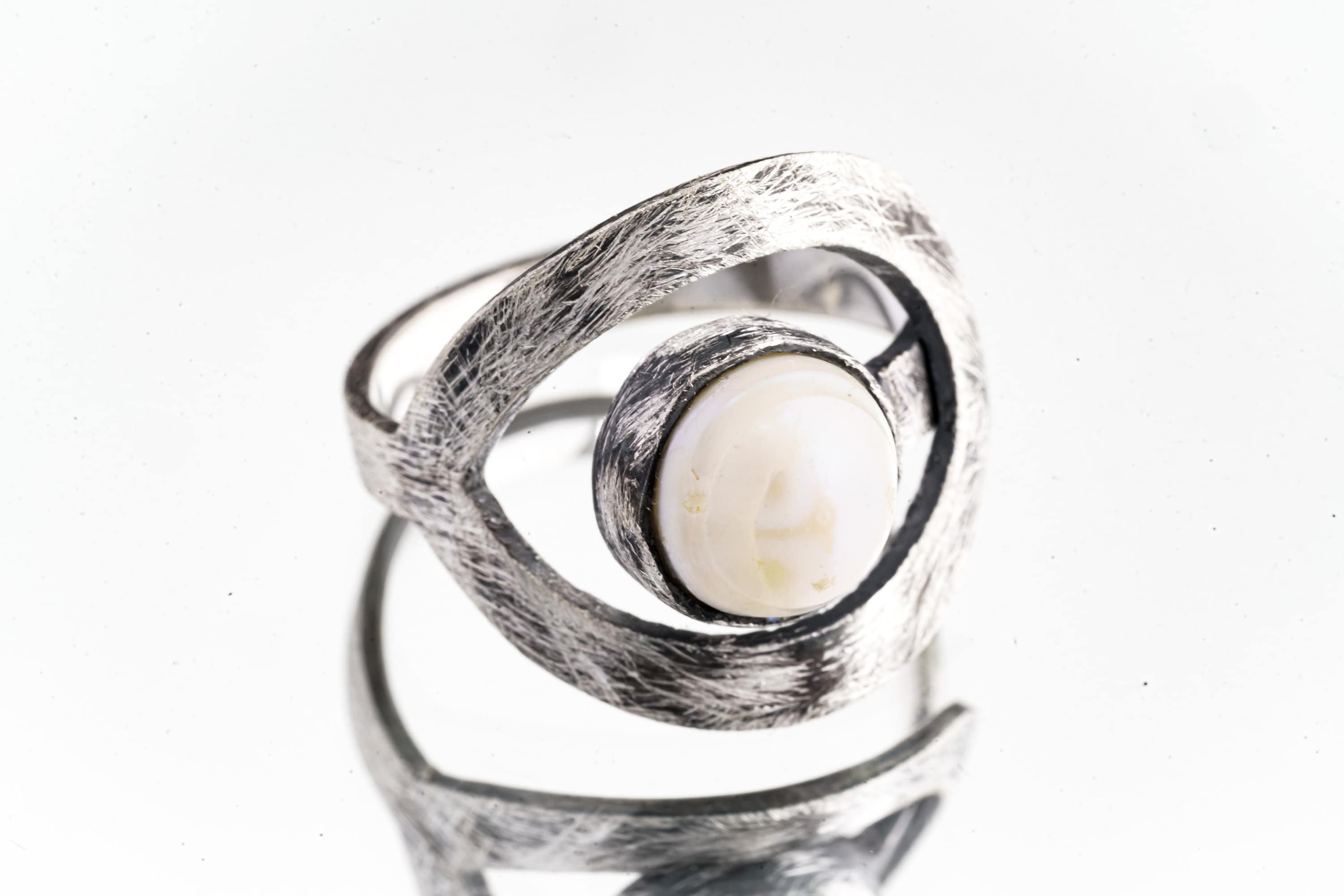 Pearl adjustable loop ring in textured 925 sterling silver shown close-up on a white background with soft organic lustre.