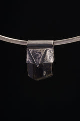 Himalayan Dravite Tourmaline Stack Pendant shown on black background with oxidized 925 silver cap and dark crystal body.
