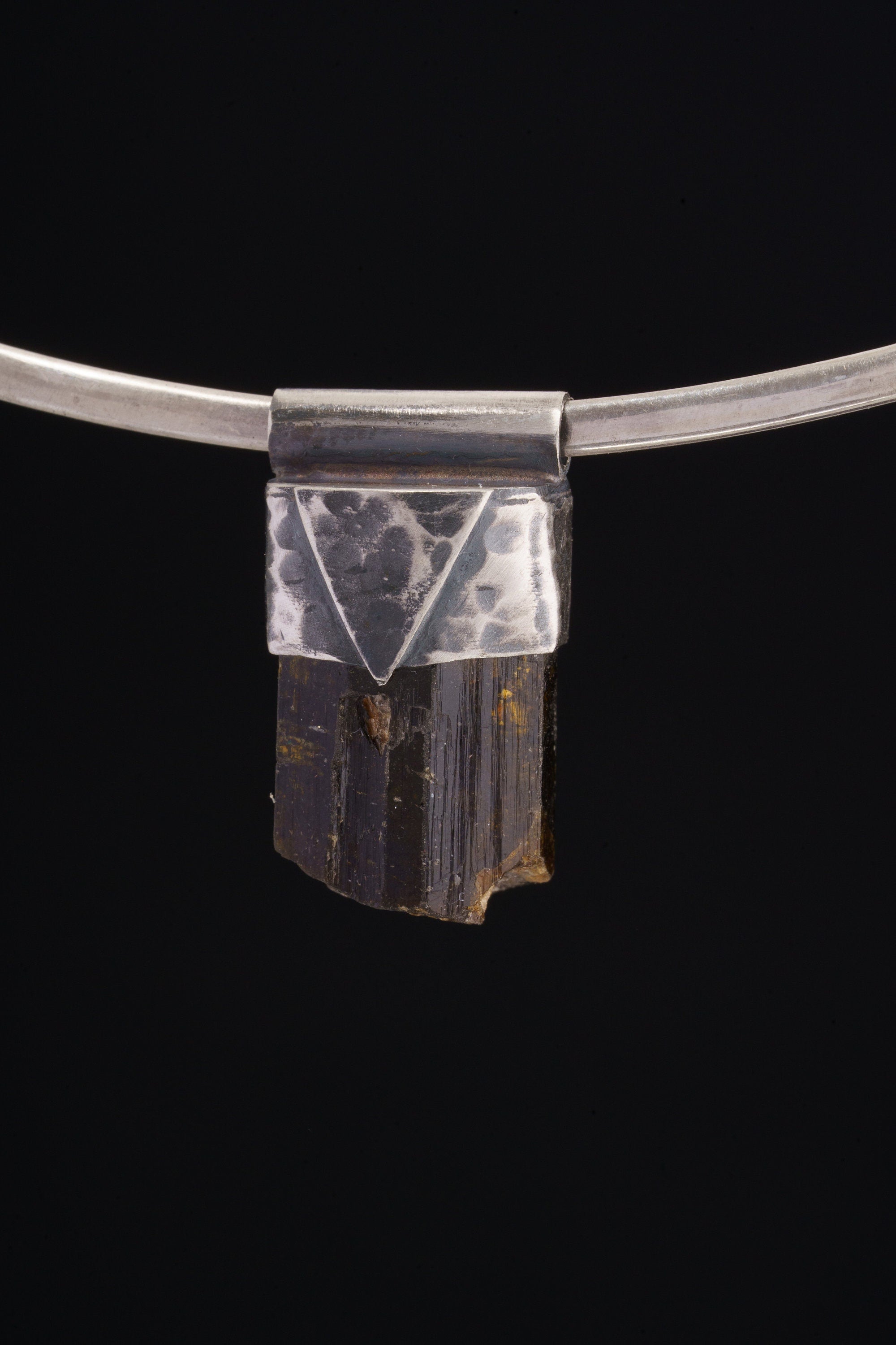 Himalayan Dravite Tourmaline Stack Pendant shown on black background with oxidized sterling silver cap and dark terminated crystal.