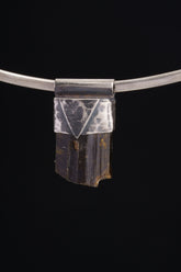 Himalayan Dravite Tourmaline Stack Pendant shown on black background with oxidized sterling silver cap and dark terminated crystal.