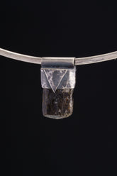 Himalayan Dravite Tourmaline Stack Pendant shown on black background with oxidized sterling silver cap and dark terminated crystal.