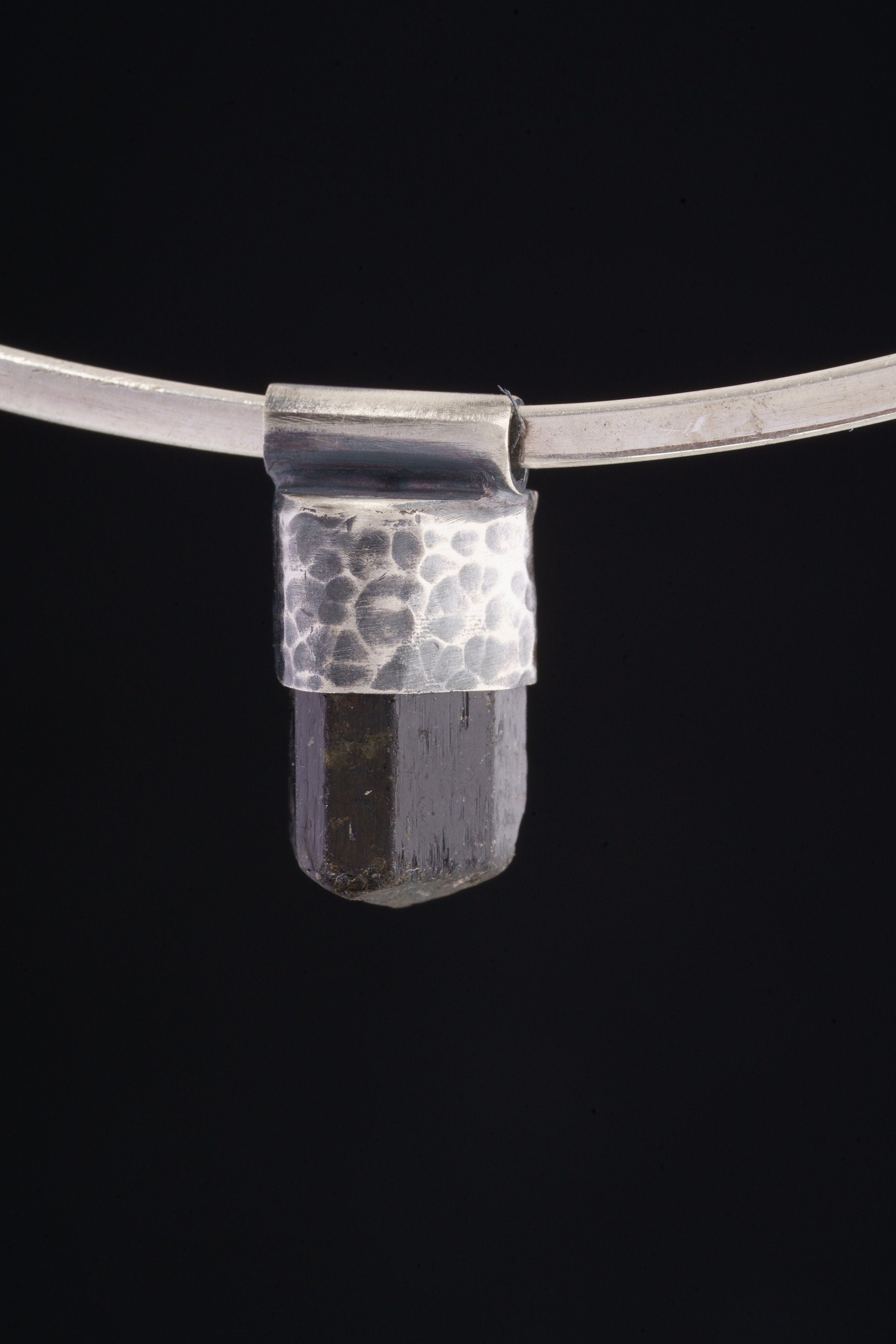 Himalayan Dravite Tourmaline Stack Pendant shown on black background with oxidized 925 silver cap and dark crystal body.
