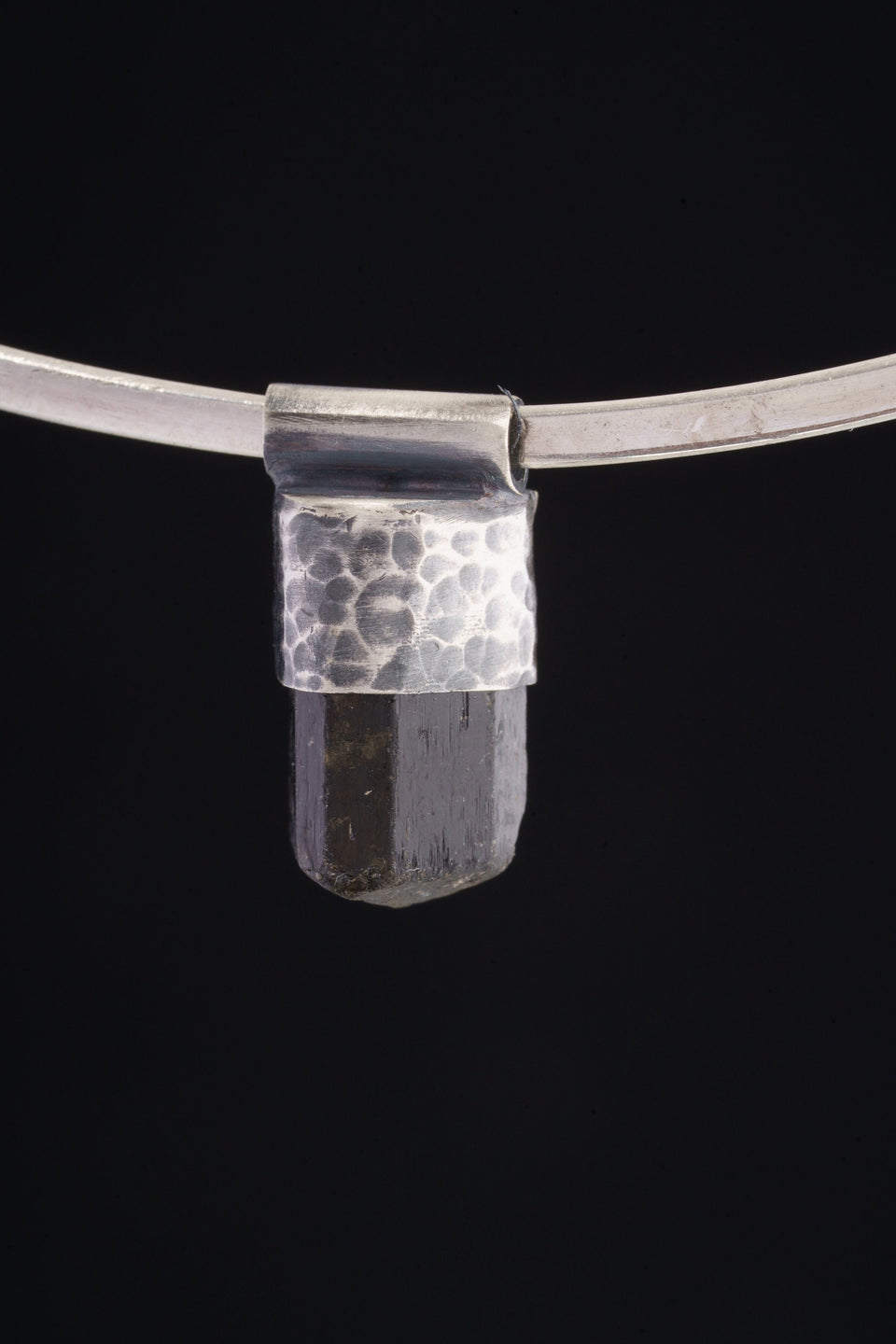 Himalayan Dravite Tourmaline Stack Pendant shown on black background with oxidized 925 silver cap and dark crystal body.