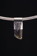 Himalayan Dravite Tourmaline Stack Pendant shown on black background with oxidized sterling silver cap and dark terminated crystal.