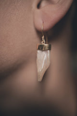 Single Pearl dangle earring shown worn on the ear, with soft pearlescent glow and handmade silver fitting.