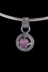 Vesuvianite Pearl Peridot pendant on black background with circular wire claw nest and gunmetal oxidized silver texture.