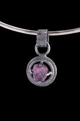 Vesuvianite Pearl Peridot pendant on black background with circular wire claw nest and gunmetal oxidized silver texture.