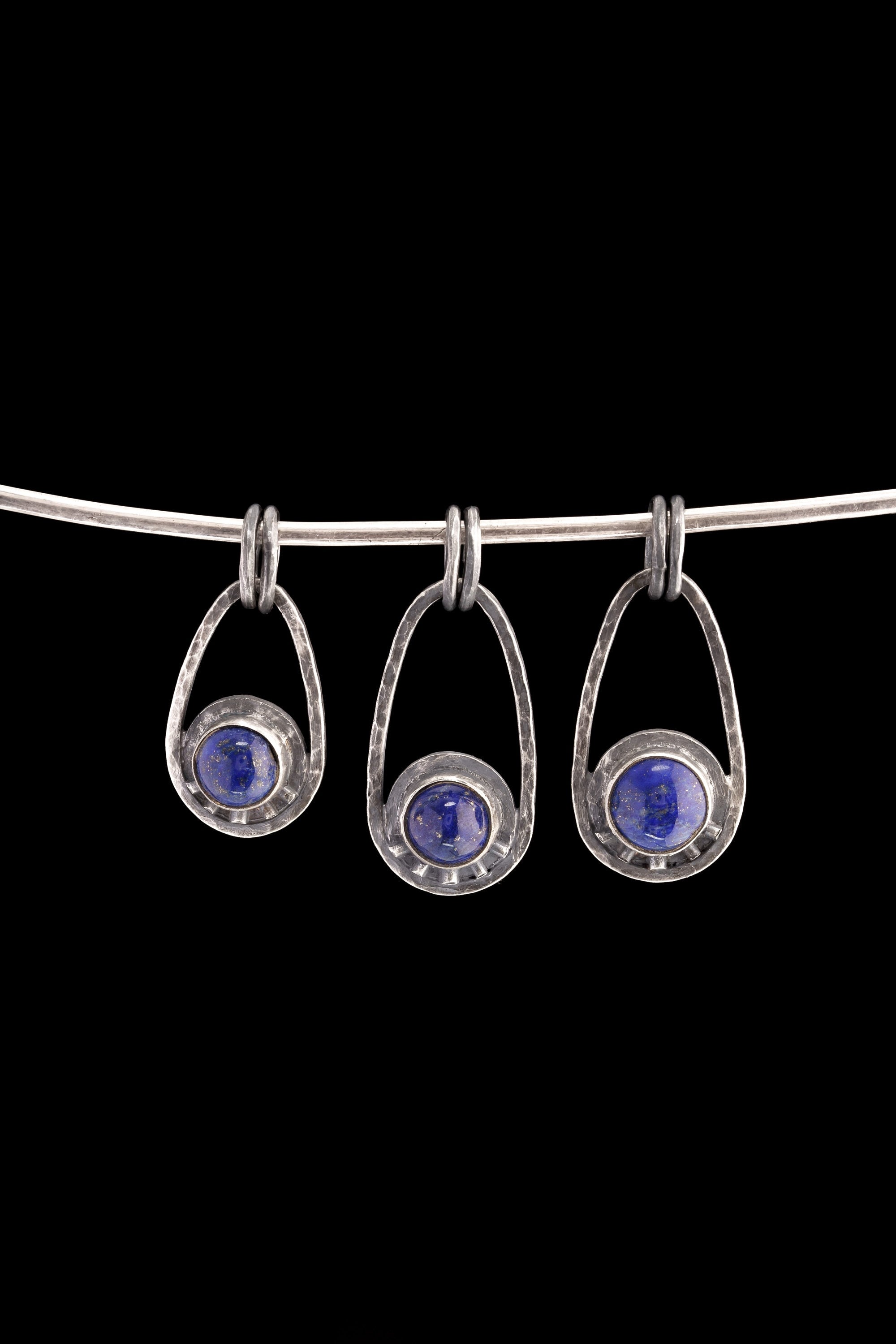 Three Lapis Lazuli Cosmic Ray pendants in polished 925 sterling silver, shown on black with deep blue stones and celestial ray details.