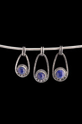 Three Lapis Lazuli Cosmic Ray pendants in polished 925 sterling silver, shown on black with deep blue stones and celestial ray details.